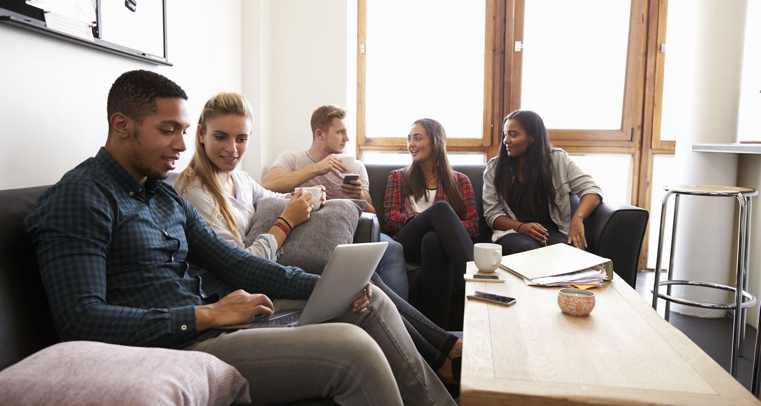 Students Relaxing In Lounge Of Shared Accommodation