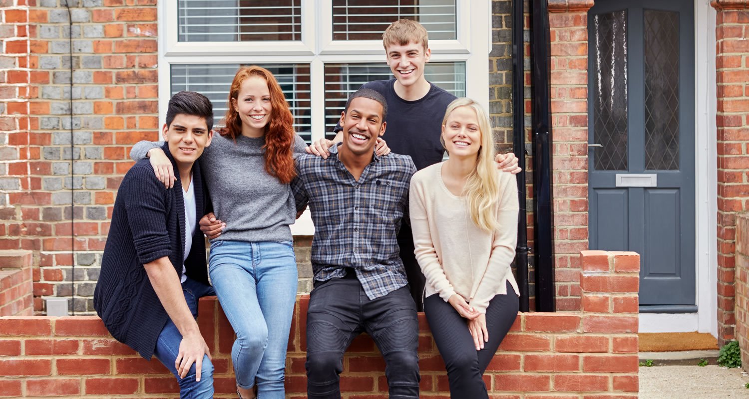 Portrait Of Group Of Smiling College Students Outside Rented Shared House