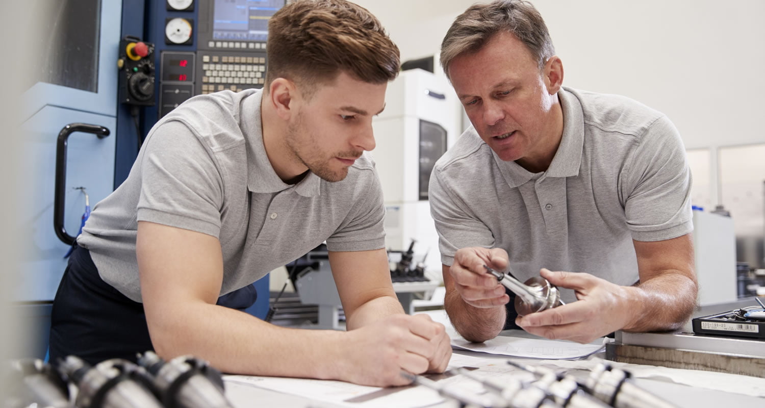 Young person in an apprenticeship position learning from employer